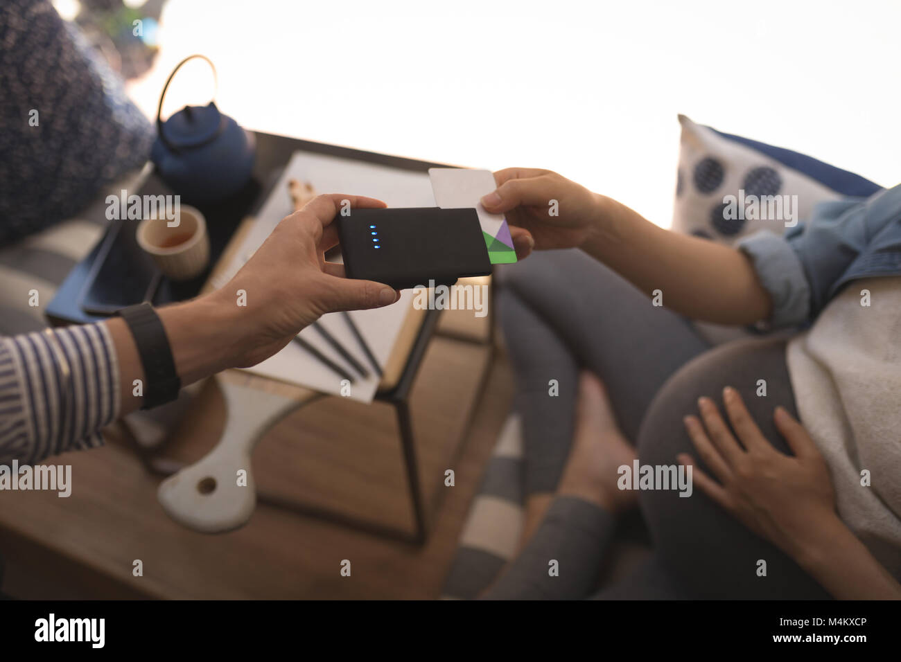 Donna incinta di effettuare il pagamento anche se bio sistema metrico Foto Stock