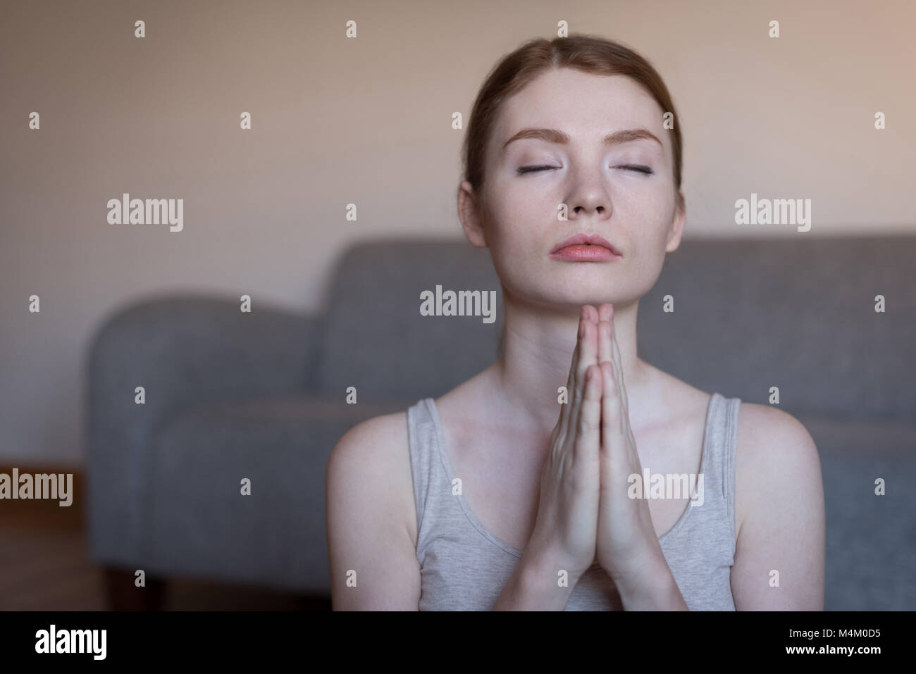 Giovane donna meditando con le mani giunte Foto Stock