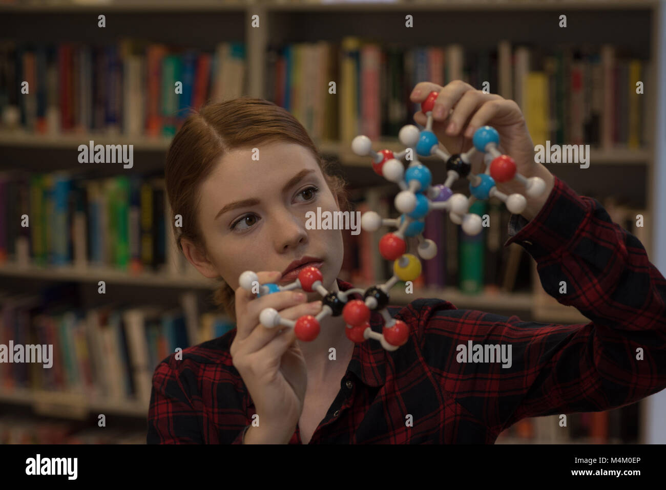 Giovane donna analizzando una molecola modello Foto Stock