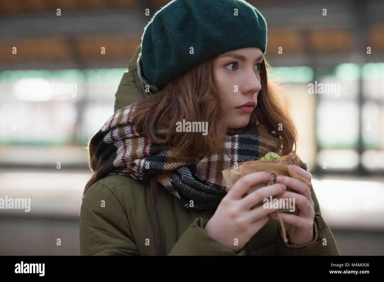Donna in abiti invernali avente un avvolgimento a stazione ferroviaria Foto Stock