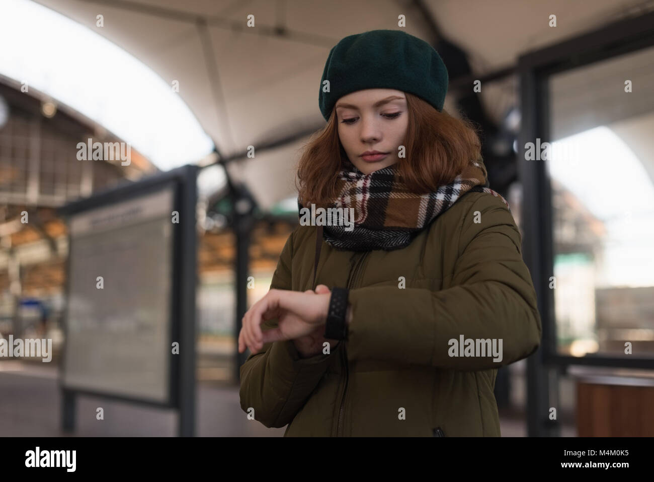Donna in abiti invernali guardando smartwatch Foto Stock