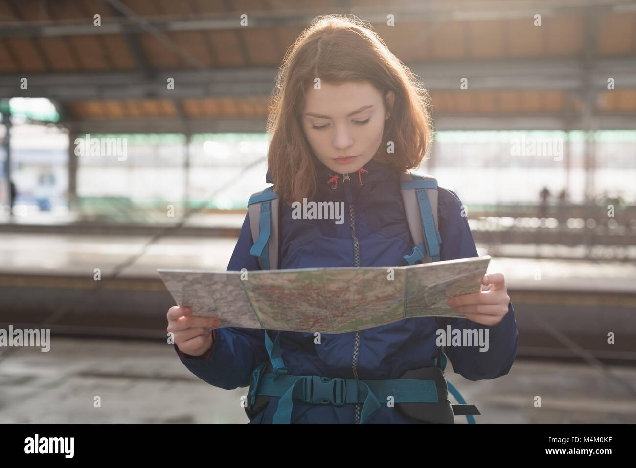Viaggiatore con zaino guardando la mappa in attesa per il treno Foto Stock
