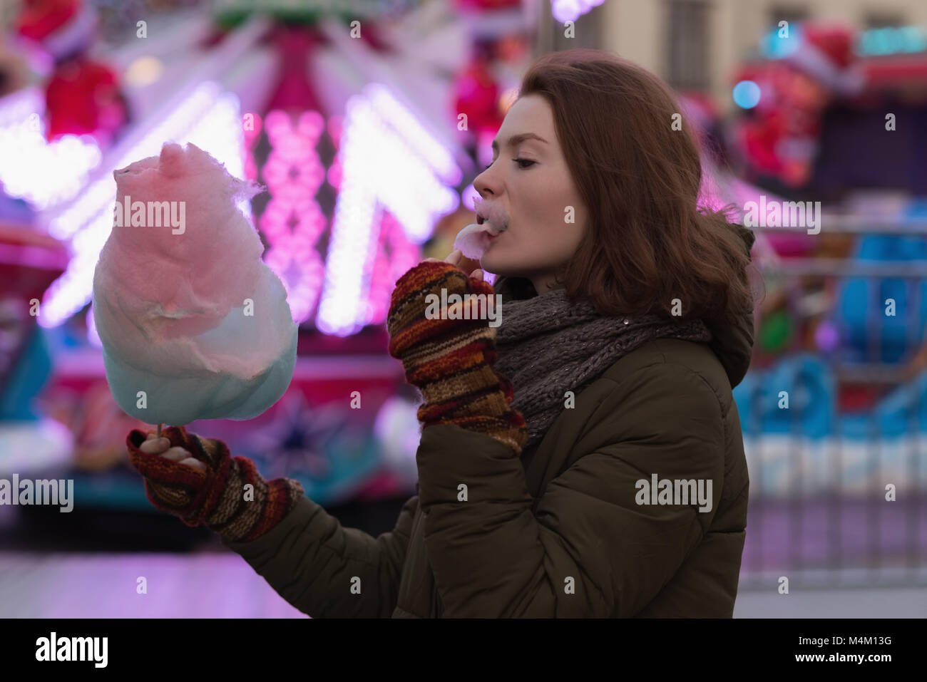Donna in abiti invernali avente Candy Floss Foto Stock