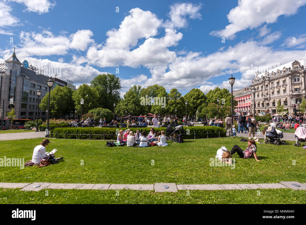 La gente seduta in erba in un parco in Karl Johans gate, Oslo, Norvegia Foto Stock