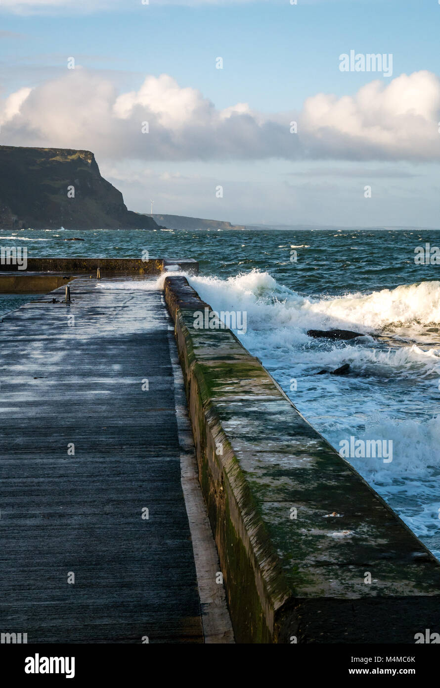 Onde si infrangono sul molo, villaggio sul mare di Crovie, a nord-est della Scozia, Regno Unito Foto Stock