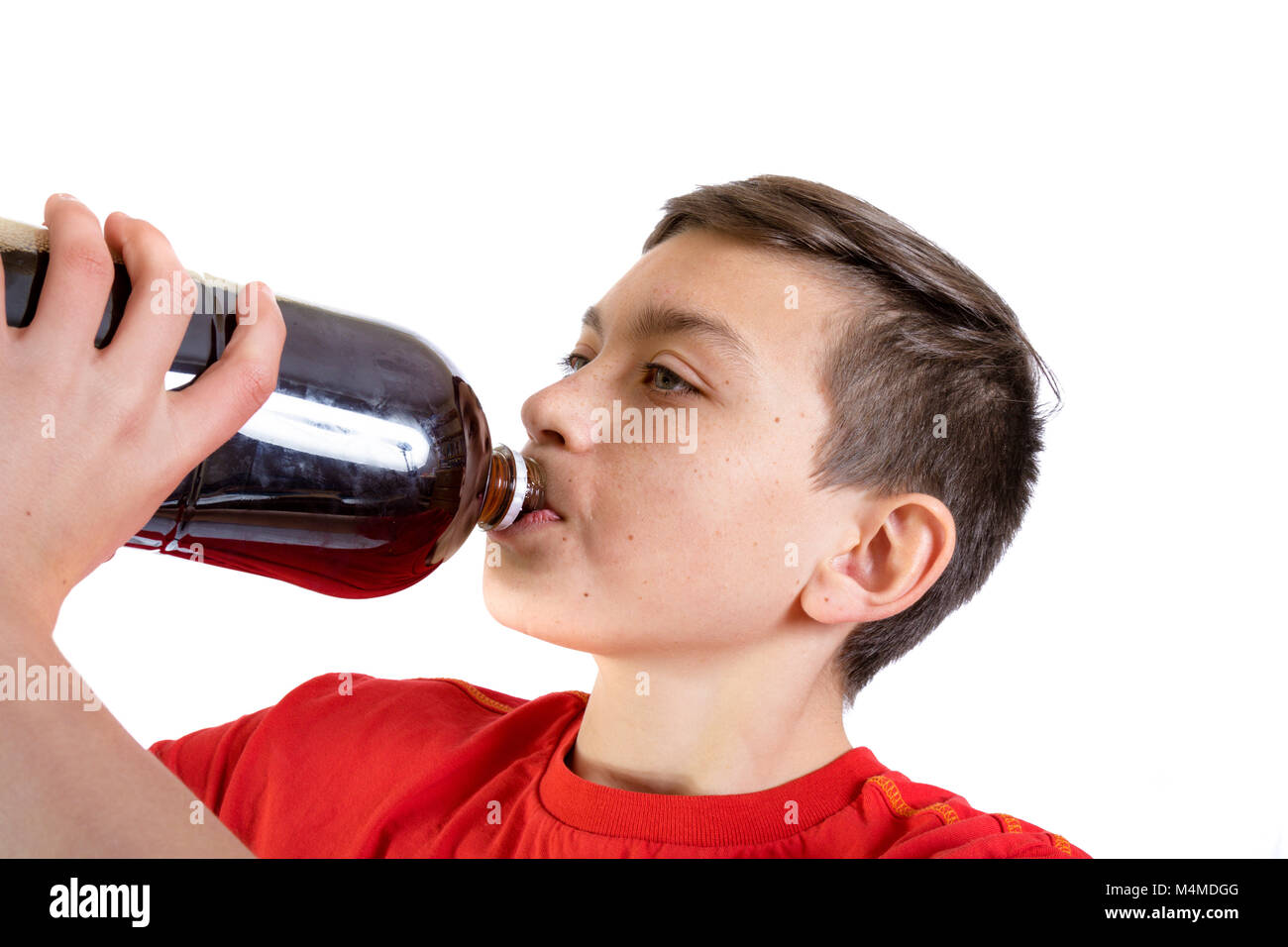 Giovani caucasici ragazzo adolescente di bere una bevanda di cola dalla bottiglia Foto Stock