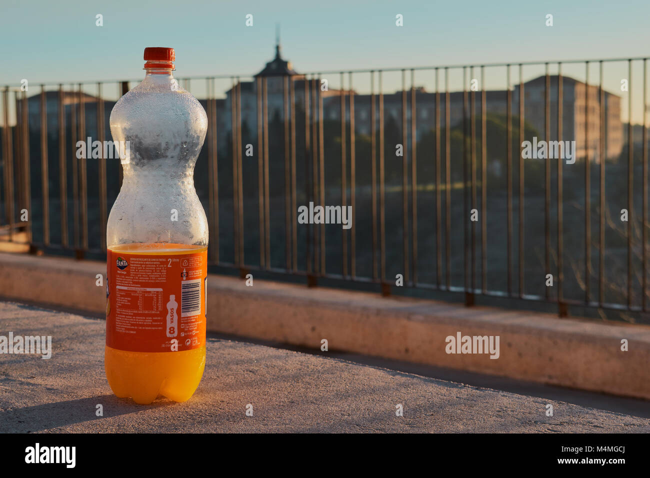 Castilla La Mancha, Toledo, Spagna. Dicembre 23 2.017: Orange Fanta bottiglia con l'Accademia di Fanteria di Toledo in background Foto Stock