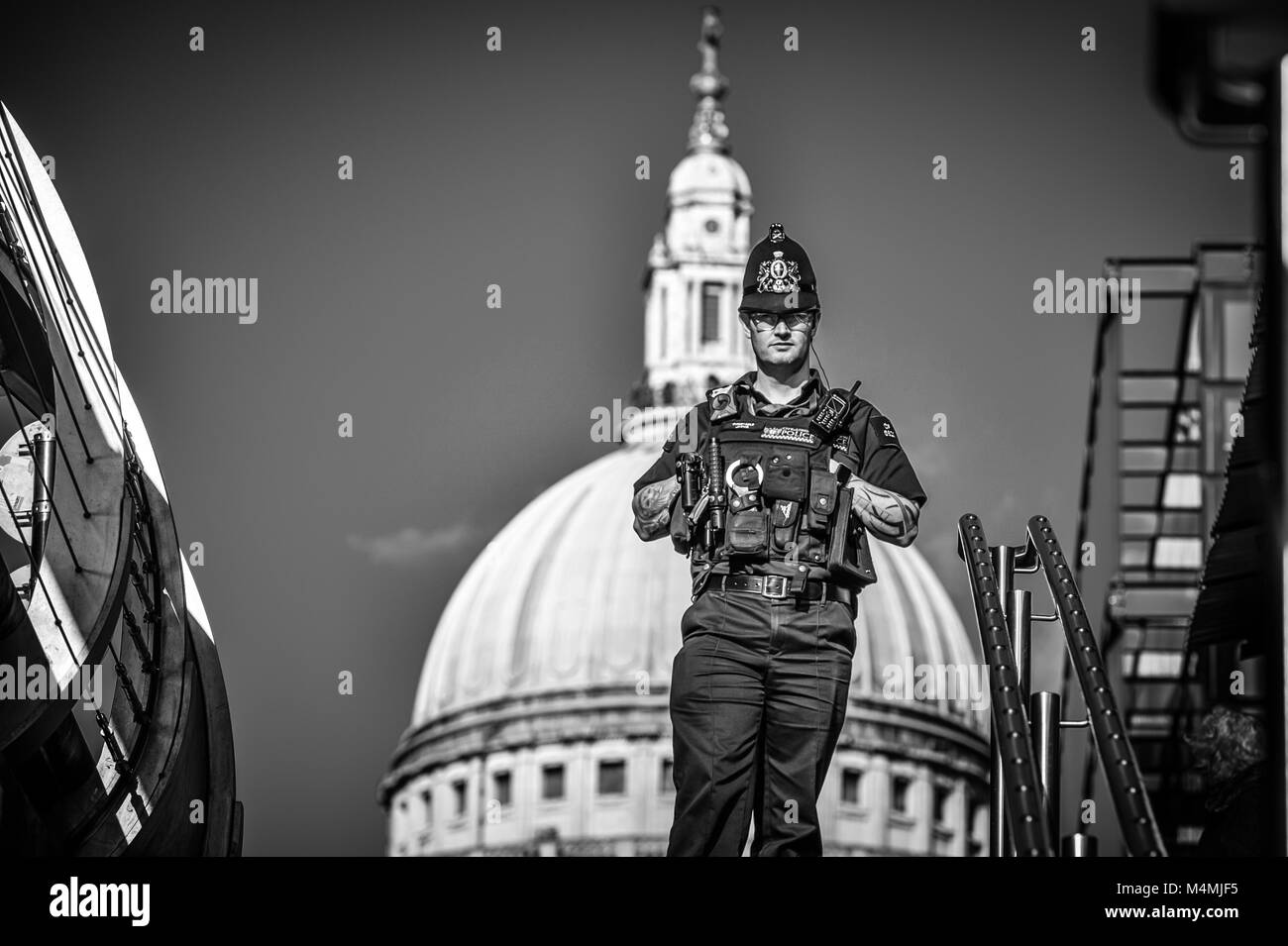 La City of London Police Officer sul Millennium Bridge, London, indossando il casco che trasportano il loro unico cappuccio cerimoniale badge Foto Stock