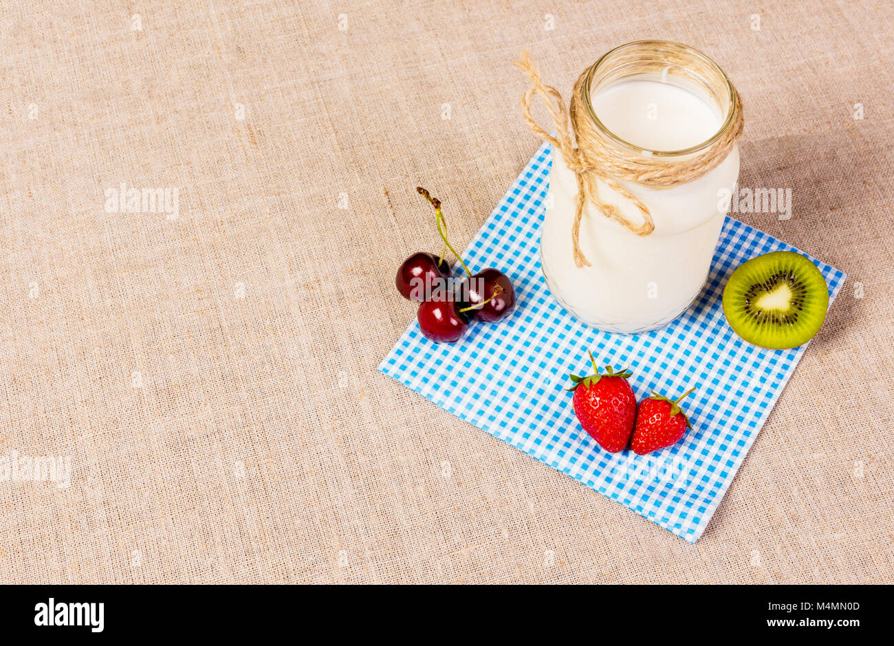 Frutta fresca e yogurt su sfondo tessili Foto Stock