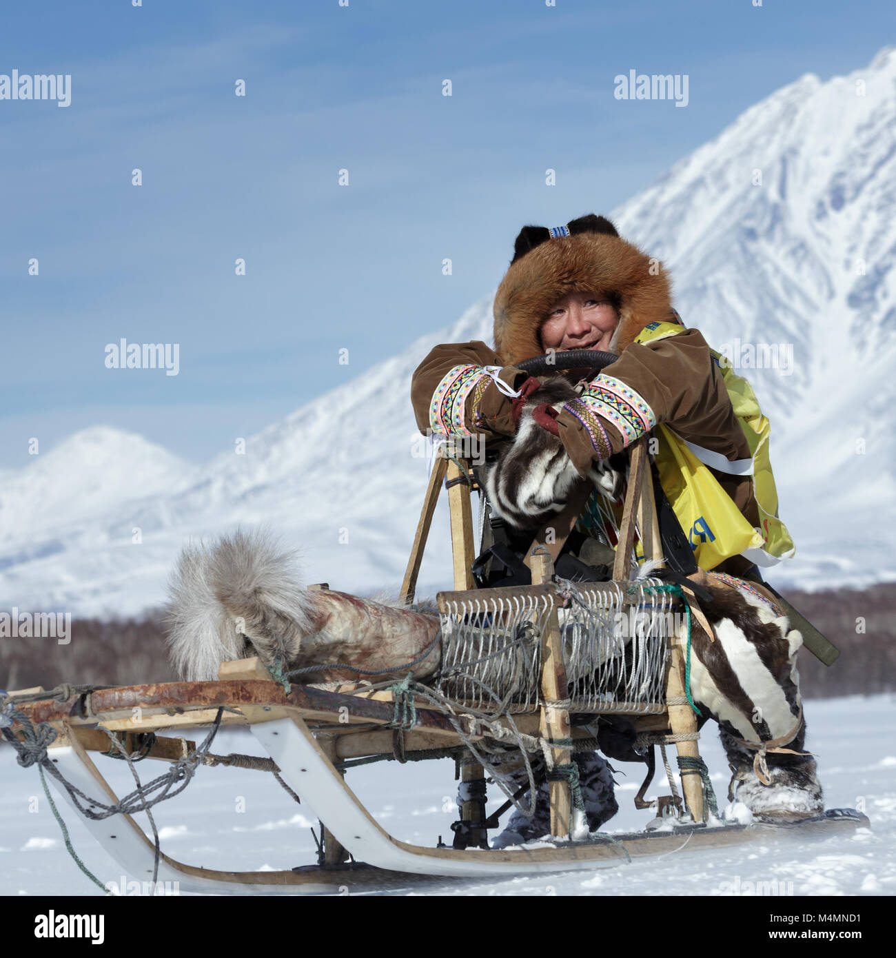 La Kamchatka musher vestito in abiti nazionali corse in slitta tradizionali dei popoli indigeni della Kamchatka. La Kamchatka Sled Dog Racing Beringia Foto Stock