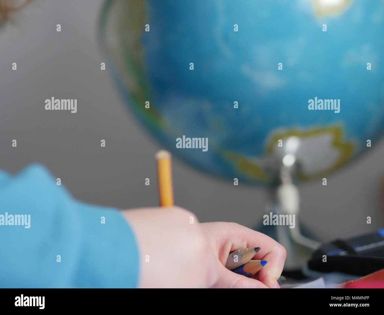 Le mani del bambino iscritto nella parte anteriore del globo Foto Stock