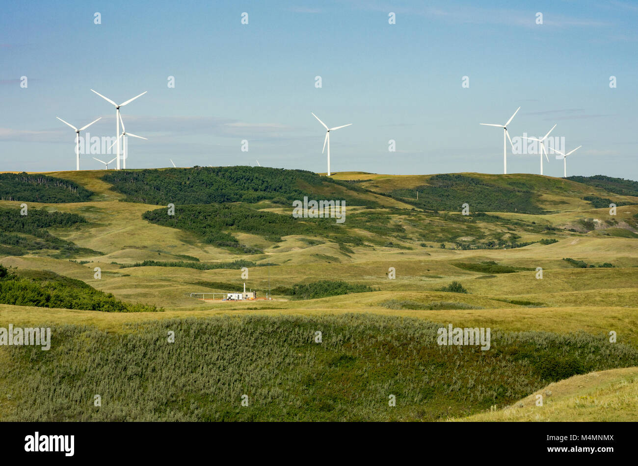 La Contea di Wheatland, Alberta, Canada. Vento rinnovabili e non rinnovabili di energia gas produzione nelle colline di svernamento a sud di Drumheller in estate. Foto Stock