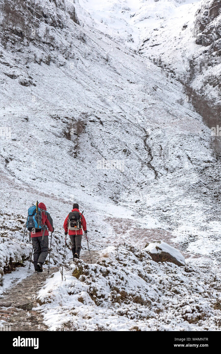 Due escursionisti femmina sul percorso verso Stob Coire nan Lochan in Glencoe area delle Highlands occidentali della Scozia durante l'inverno. Foto Stock