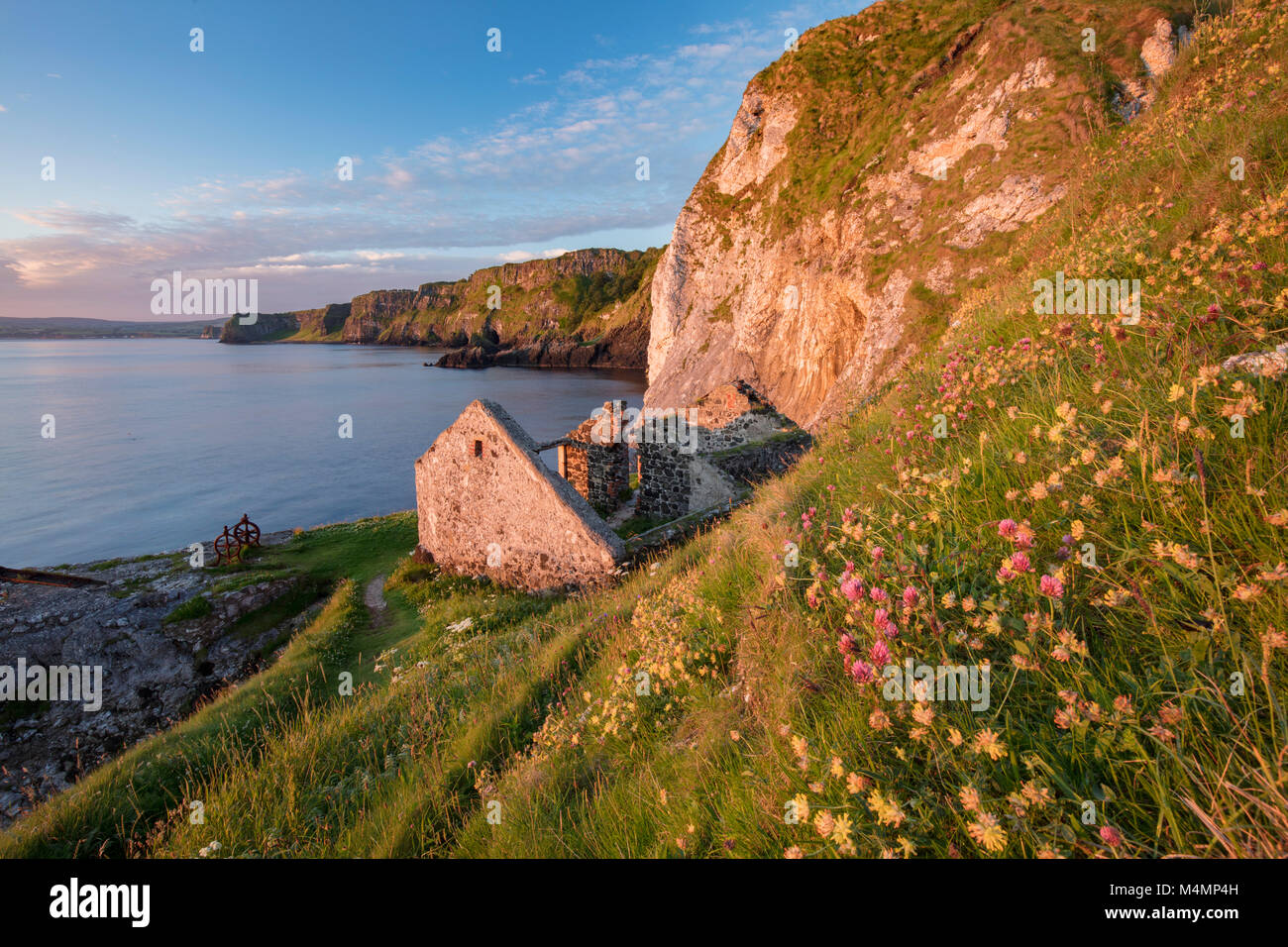 Vecchio cottage di pesca sotto le scogliere a testa Kinbane, Ballycastle, paese di Antrim, Irlanda del Nord. Foto Stock