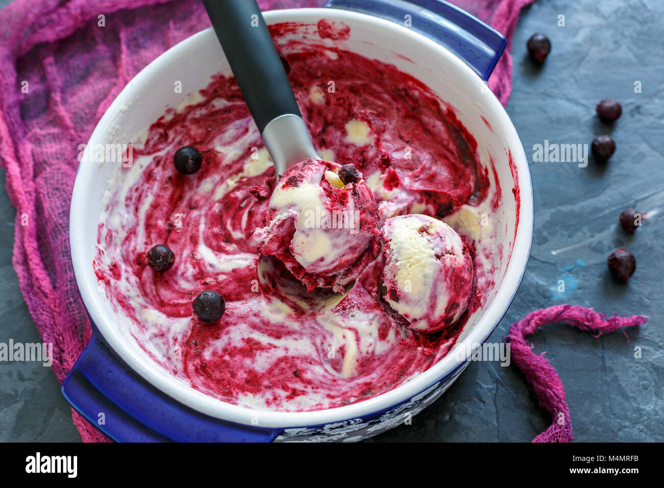 Gelato alla vaniglia con il ribes nero e il cucchiaio. Foto Stock