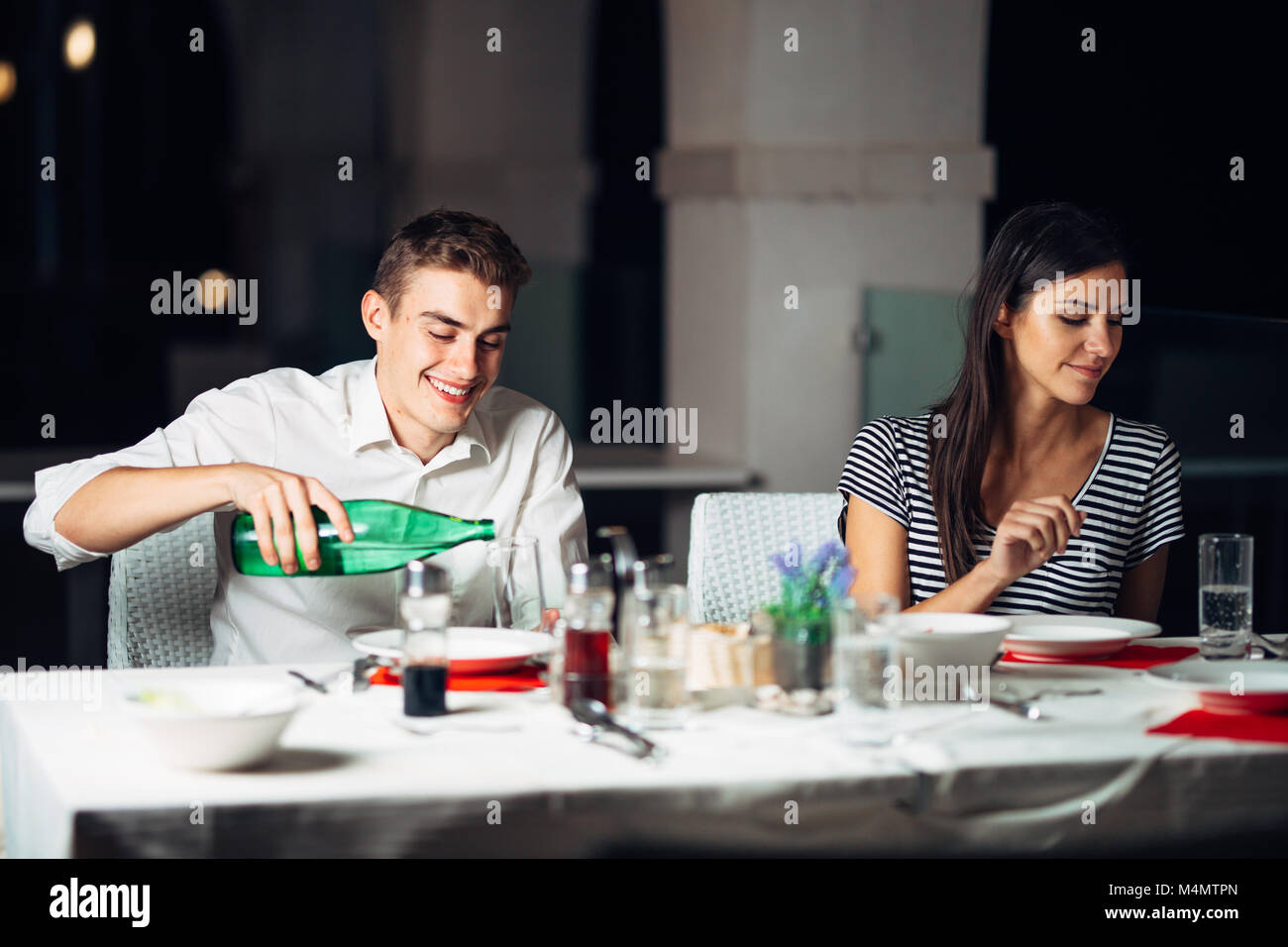 Donna sorridente su una data in un ristorante,avente una conversazione con un pasto in hotel.Allegro cliente femmina di bere il caffè con un partner.em positivo Foto Stock