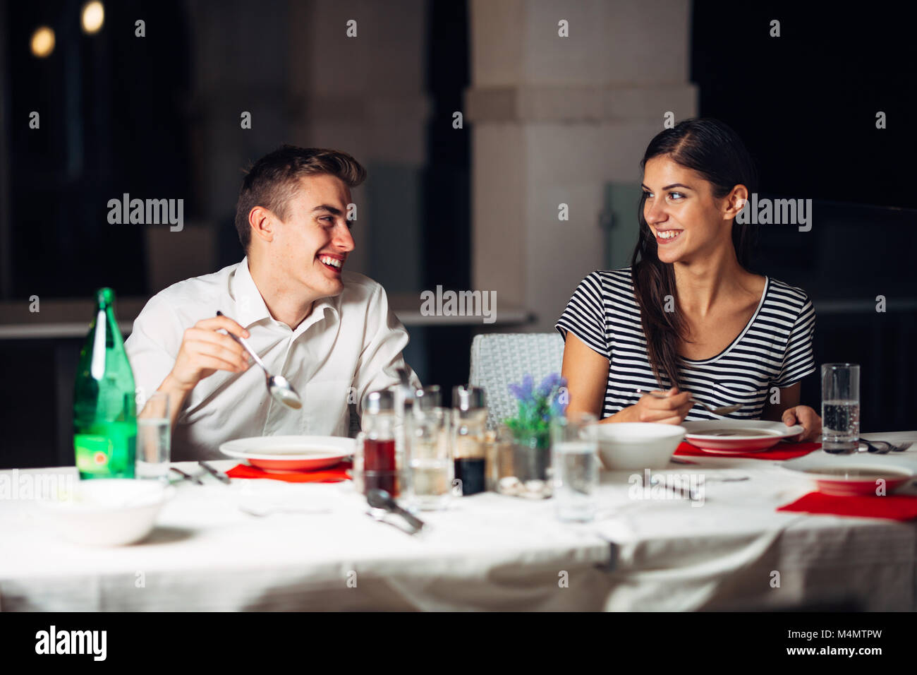 Donna sorridente su una data in un ristorante,avente una conversazione con un pasto in hotel.Allegro cliente femmina di bere il caffè con un partner.em positivo Foto Stock