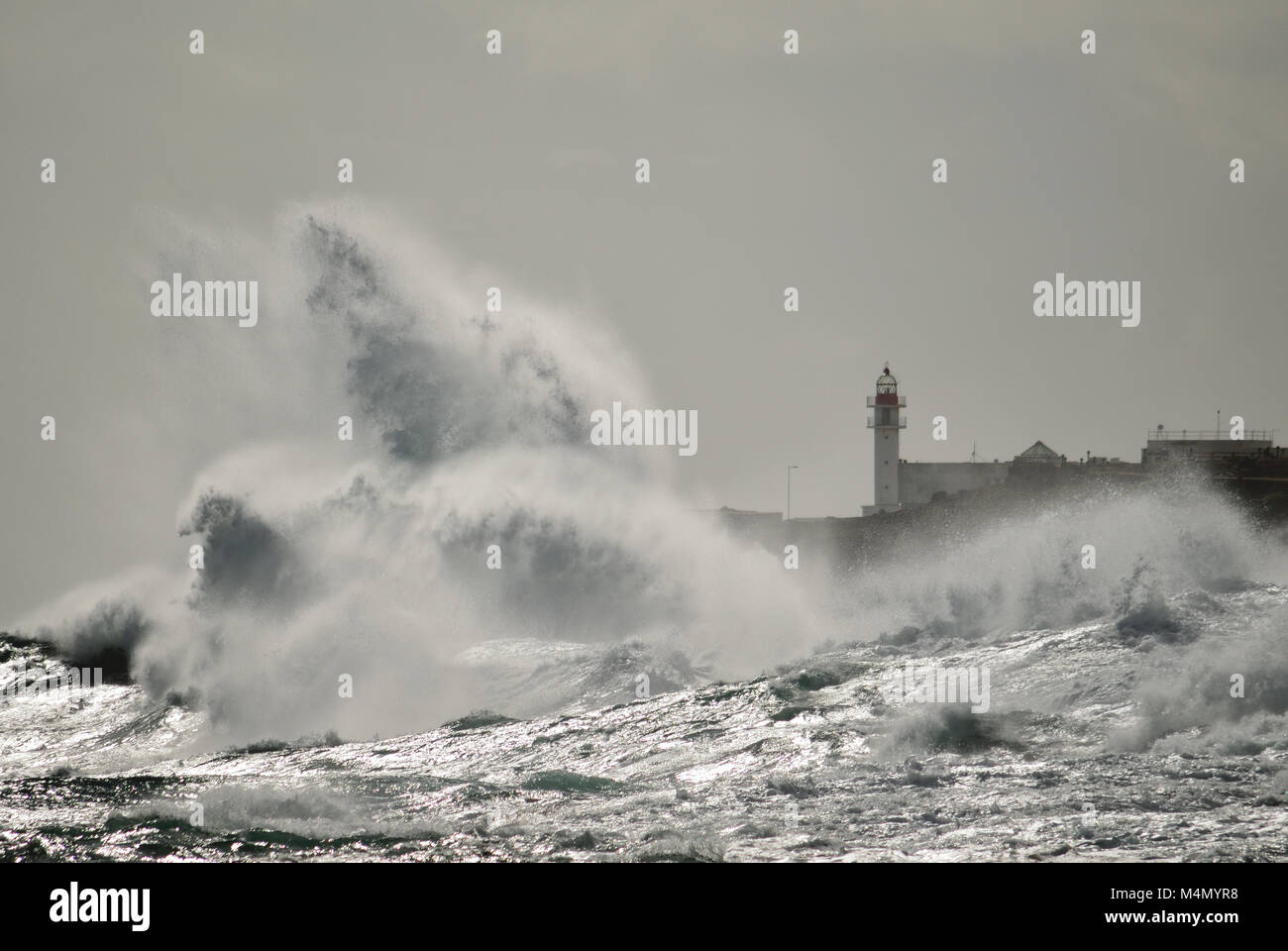 Onde forti e faro in background, Taliarte, costa di Telde, isole Canarie Foto Stock