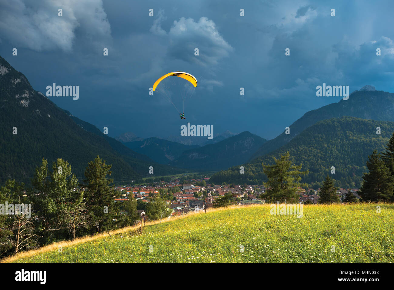 Parapendio volando sopra la valle di montagna vicino a Mittenwald, Germania Foto Stock