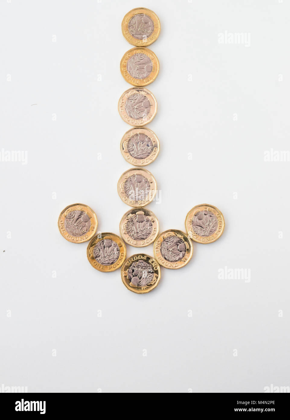 Una freccia verso il basso formate da undici nuovi British pound monete Foto Stock