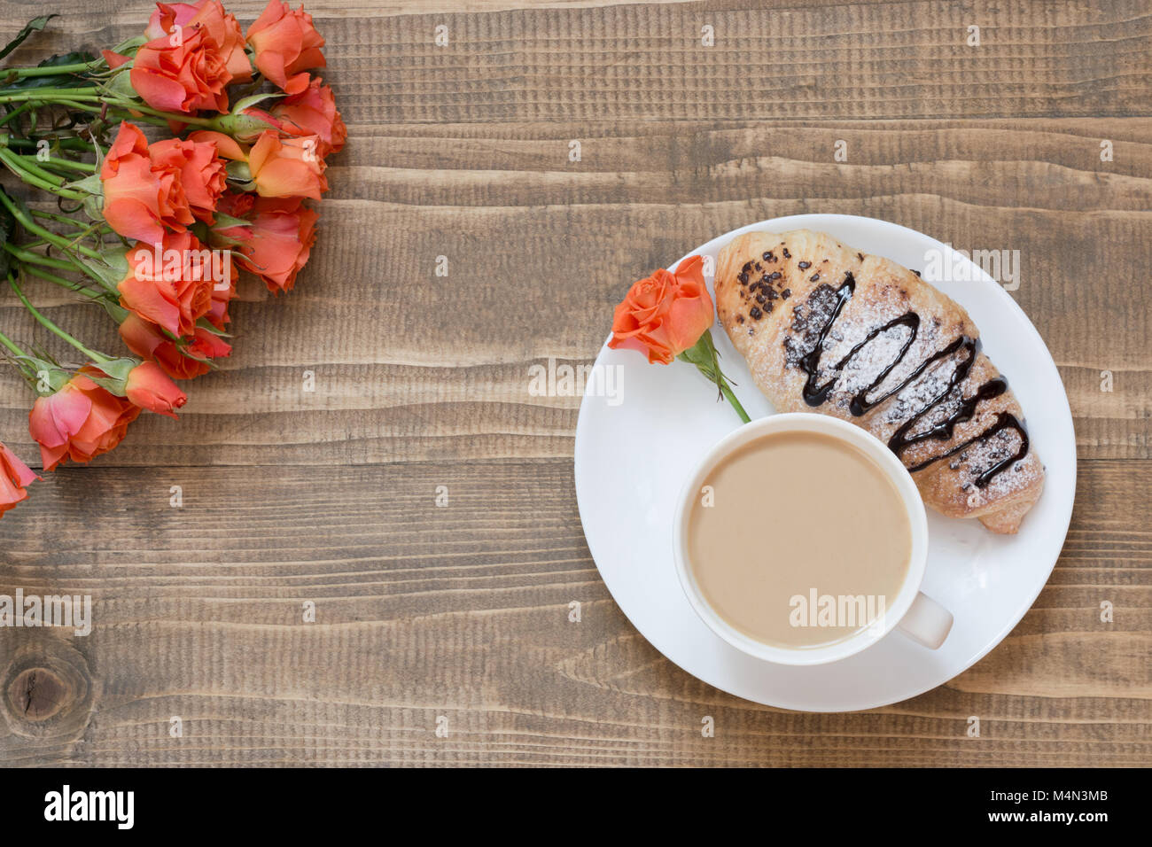 Due deliziosi appena sfornato croissant al cioccolato e caffè sulla tavola di legno. Vista dall'alto. Colazione femmina concetto. Copia dello spazio. Foto Stock