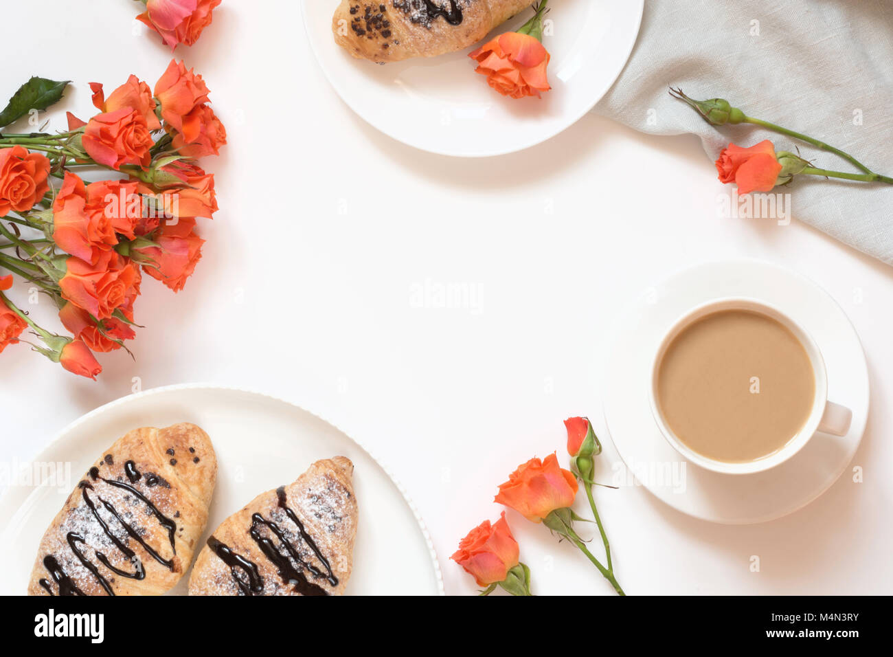 Pane appena sfornato croissant al cioccolato e la tazza di caffè sul tavolo bianco. Vista dall'alto. Colazione femmina concetto. Copia dello spazio. Foto Stock