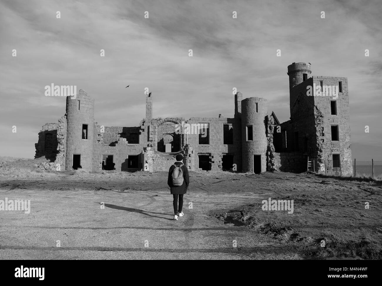 Gli escursionisti a piedi verso la rovina di nuovo Slains castello su un soleggiato inverni giorno. Cruden Bay, Aberdeenshire, Scotland, Regno Unito. Febbraio, 2018. Foto Stock