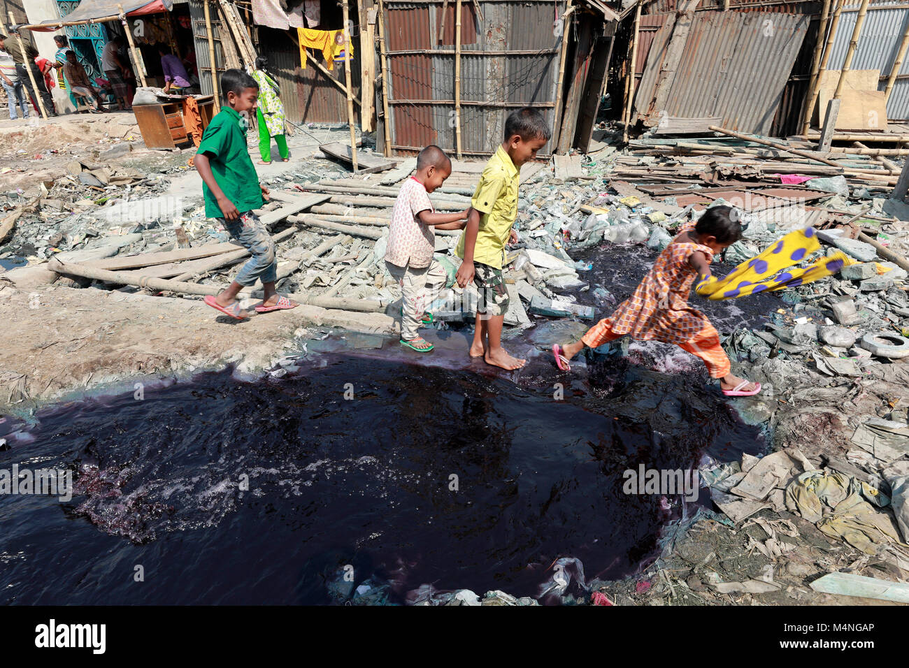 Dacca in Bangladesh. Xvi Feb, 2018. Una ragazza del Bangladesh attraversa un canale pieno con prodotto chimico tossico a Dhaka, nel Bangladesh. Rifiuti tossici prodotti dalle industrie ha girato acqua in rosso. Credito: SK Hasan Ali/Alamy Live News Foto Stock