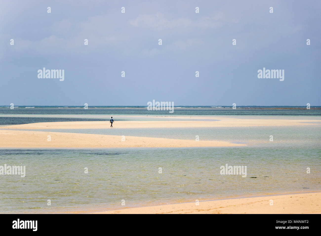 Lone persona che cammina desert island beach in Mozambico con mare turchese Foto Stock