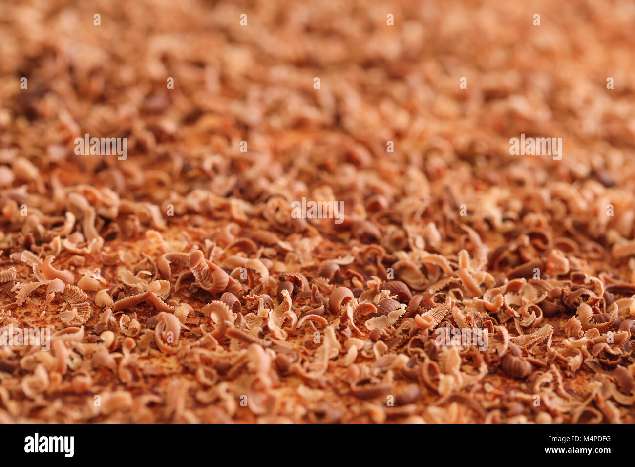 Scaglie di cioccolato, extreme macro. Close up di sottili scaglie di cioccolato e riccioli tritato manualmente sulla torta texture. Migliore immagine di gustoso riccioli di cioccolato Foto Stock