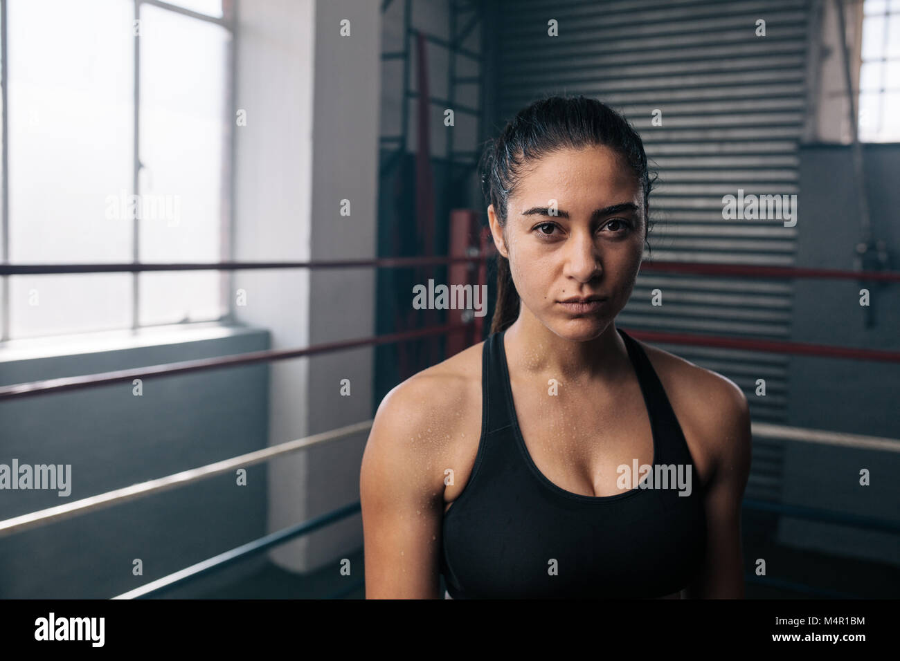 Boxer femmina all'interno di un anello di inscatolamento. Donna boxer in un boxing studio. Foto Stock