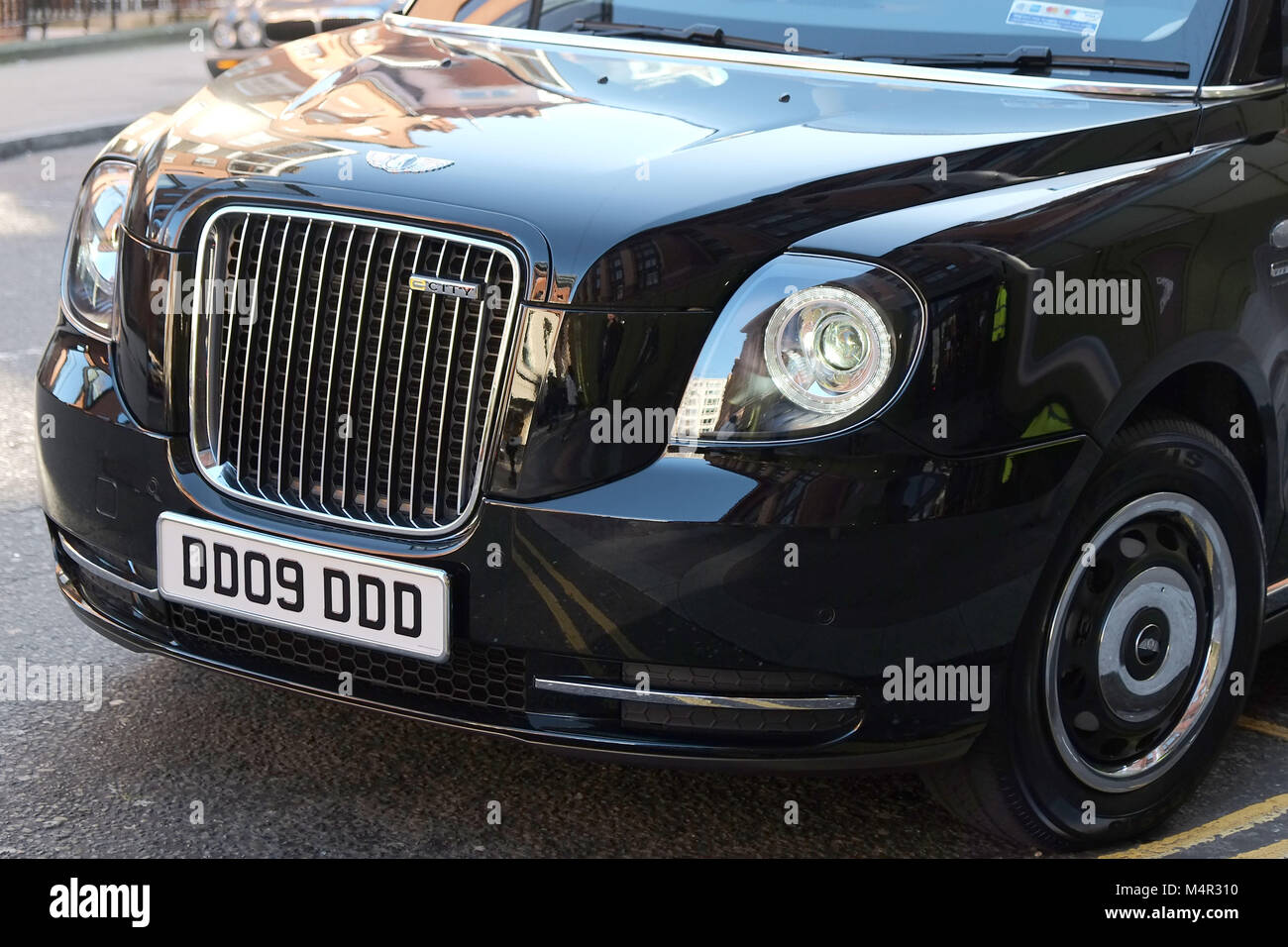 London Black Cab è andato verde come un nuovo taxi elettrico attende al di fuori di Harrods in Knightsbridge a prendere i passeggeri sul capitale nelle strade. Foto Stock
