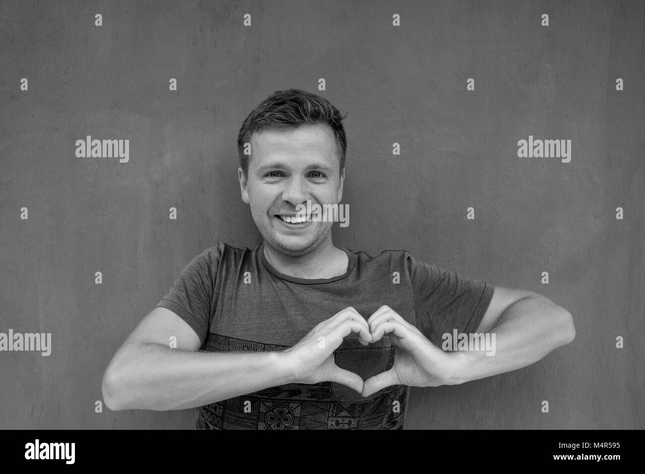 Foto in bianco e nero di uomo caucasico facendo un lato telaio del cuore Foto Stock