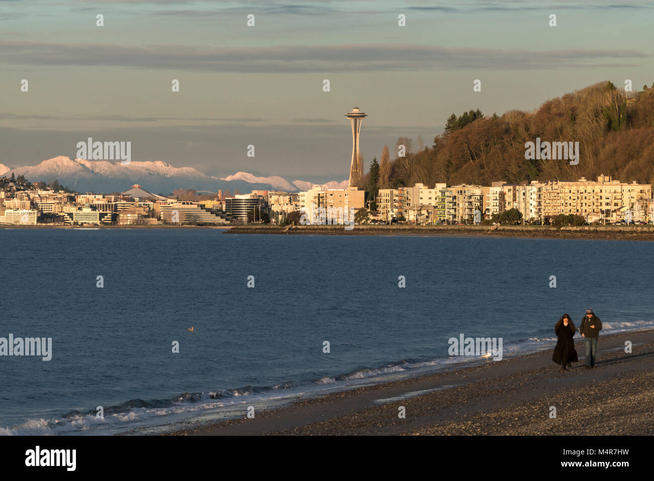 Giovane camminando sulla spiaggia di Alki in inverno, Seattle, Washington Foto Stock