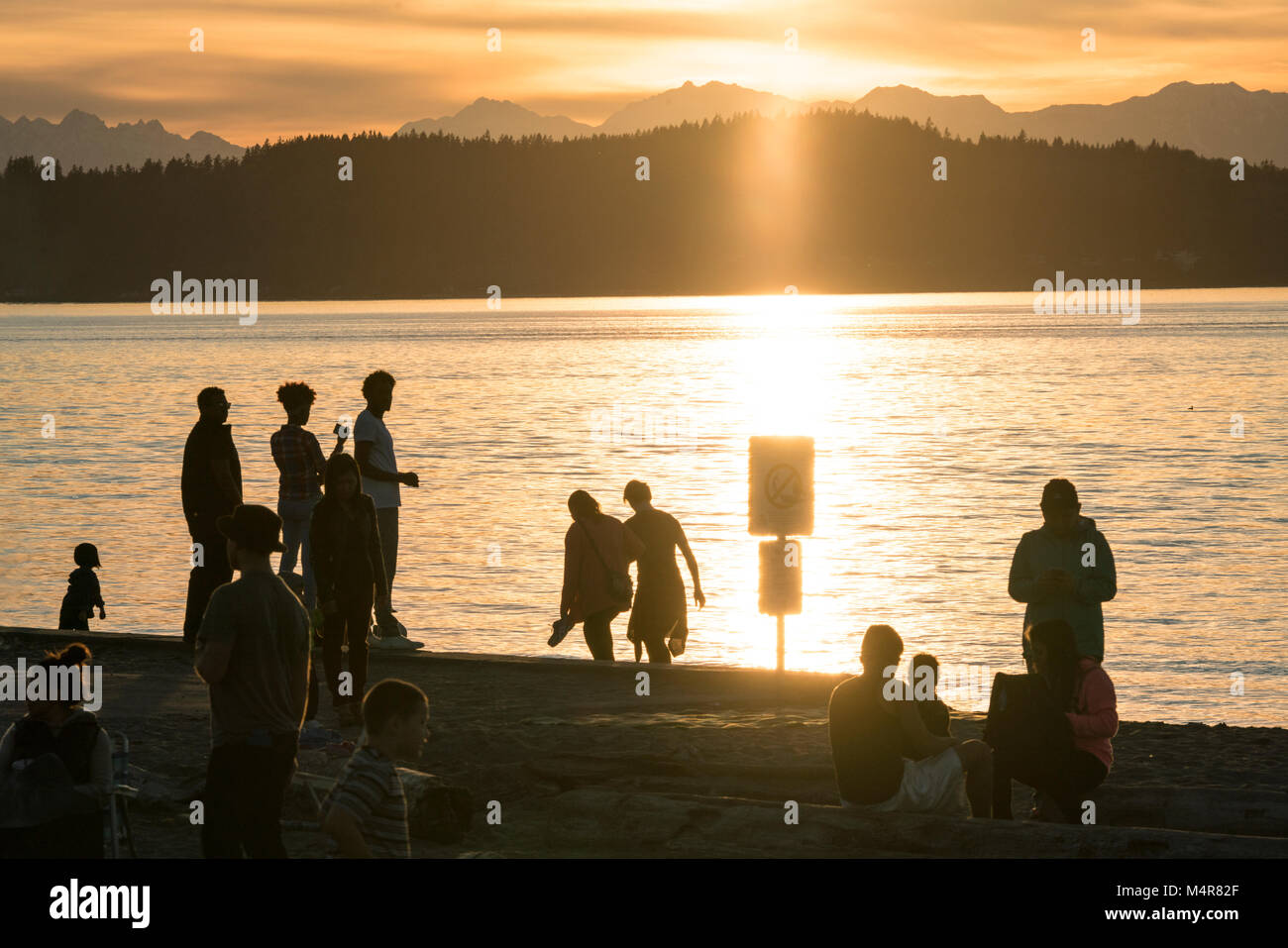 Le persone che si godono il tramonto sulla spiaggia di Alki, Seattle Washington, Stati Uniti d'America Foto Stock