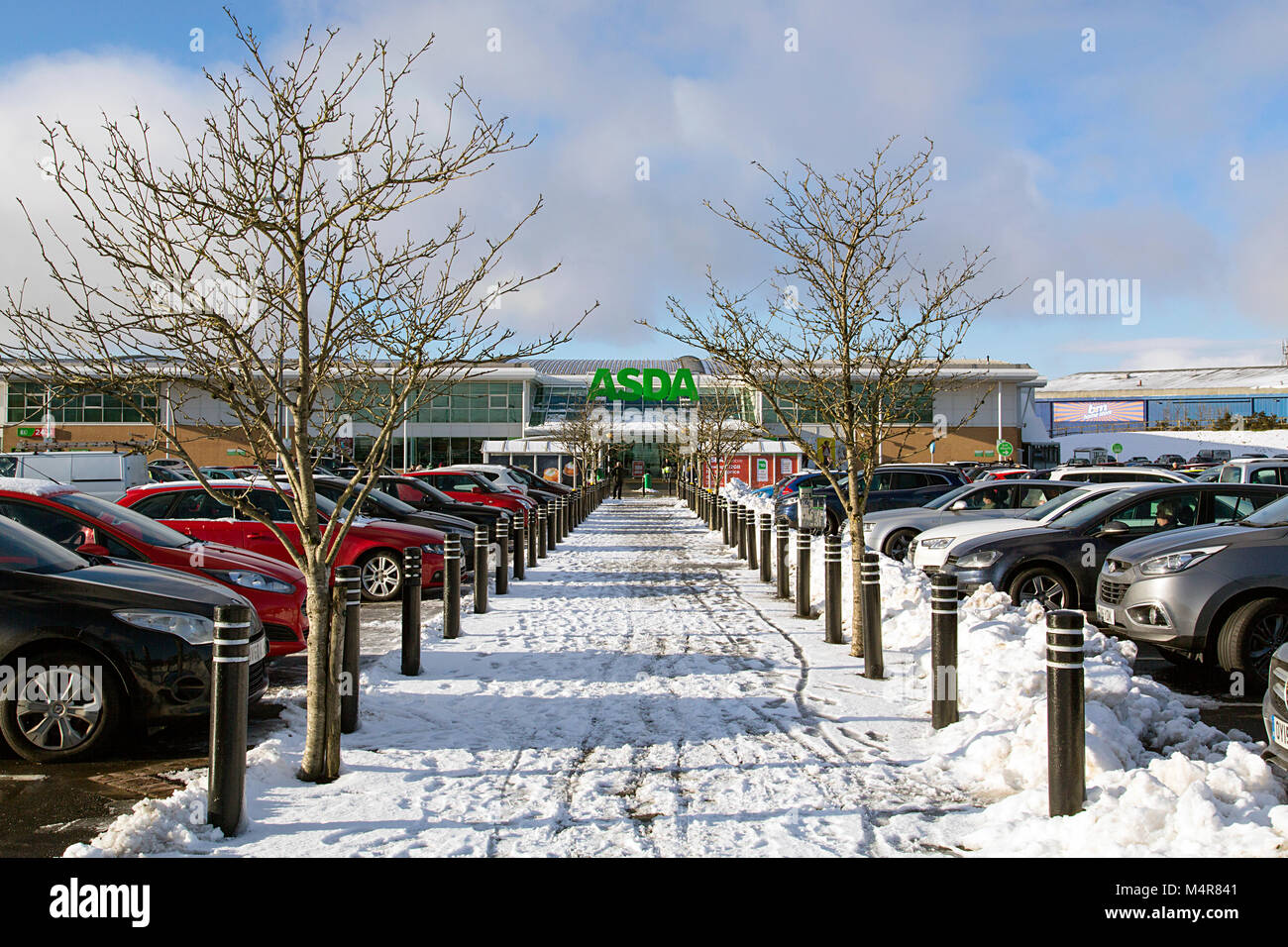 Merthry Tydfil, Wales UK: Dicembre 28, 2017: Asda si adoperano per mantenere il parco auto e i sentieri sicuri per i loro clienti durante una pesante caduta di neve. Foto Stock