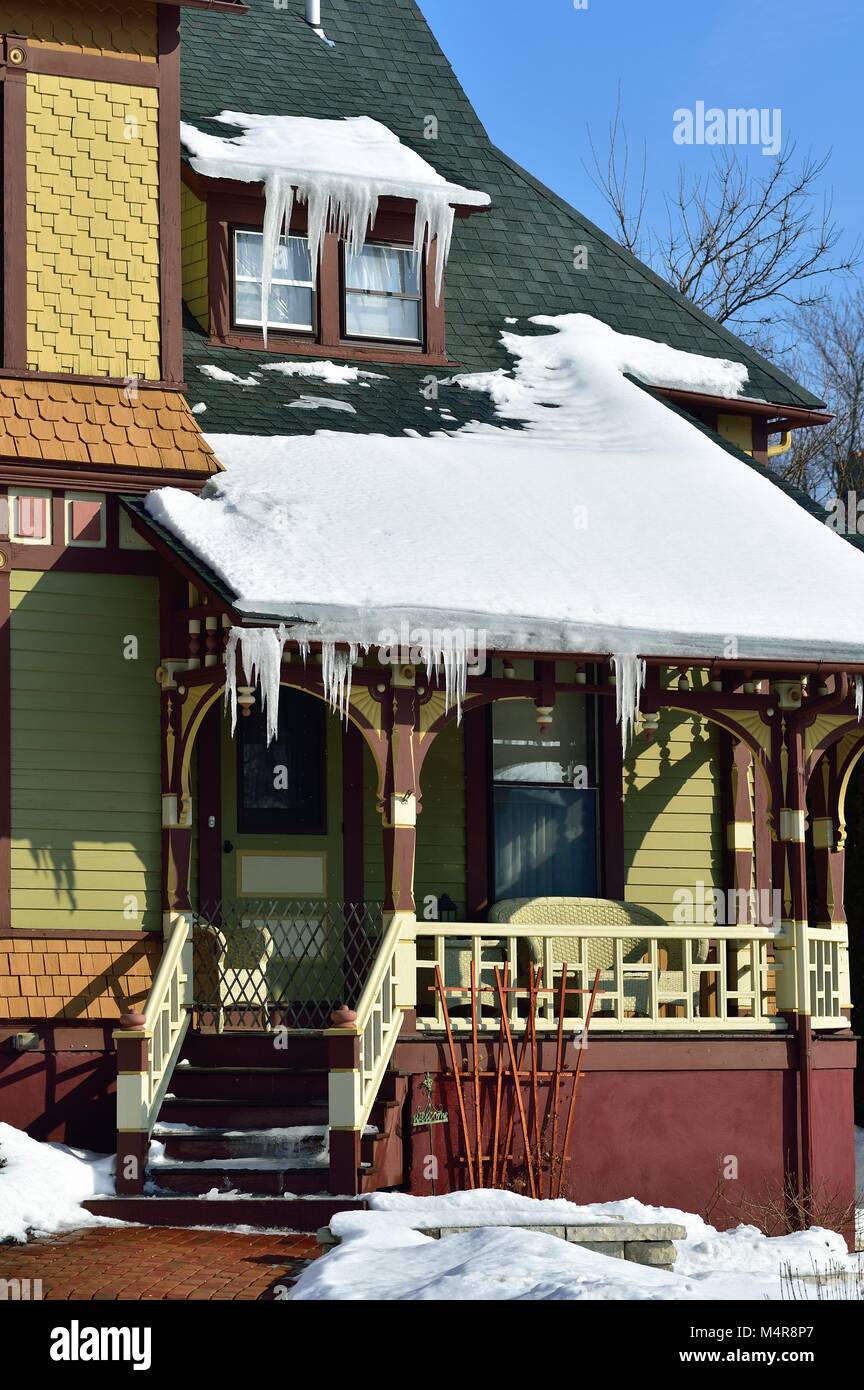 Un venerabile, vintage home sporting ghiaccioli che mostra segni di un inverno sgelare nel sole del pomeriggio. Elgin, Illinois, Stati Uniti d'America. Foto Stock