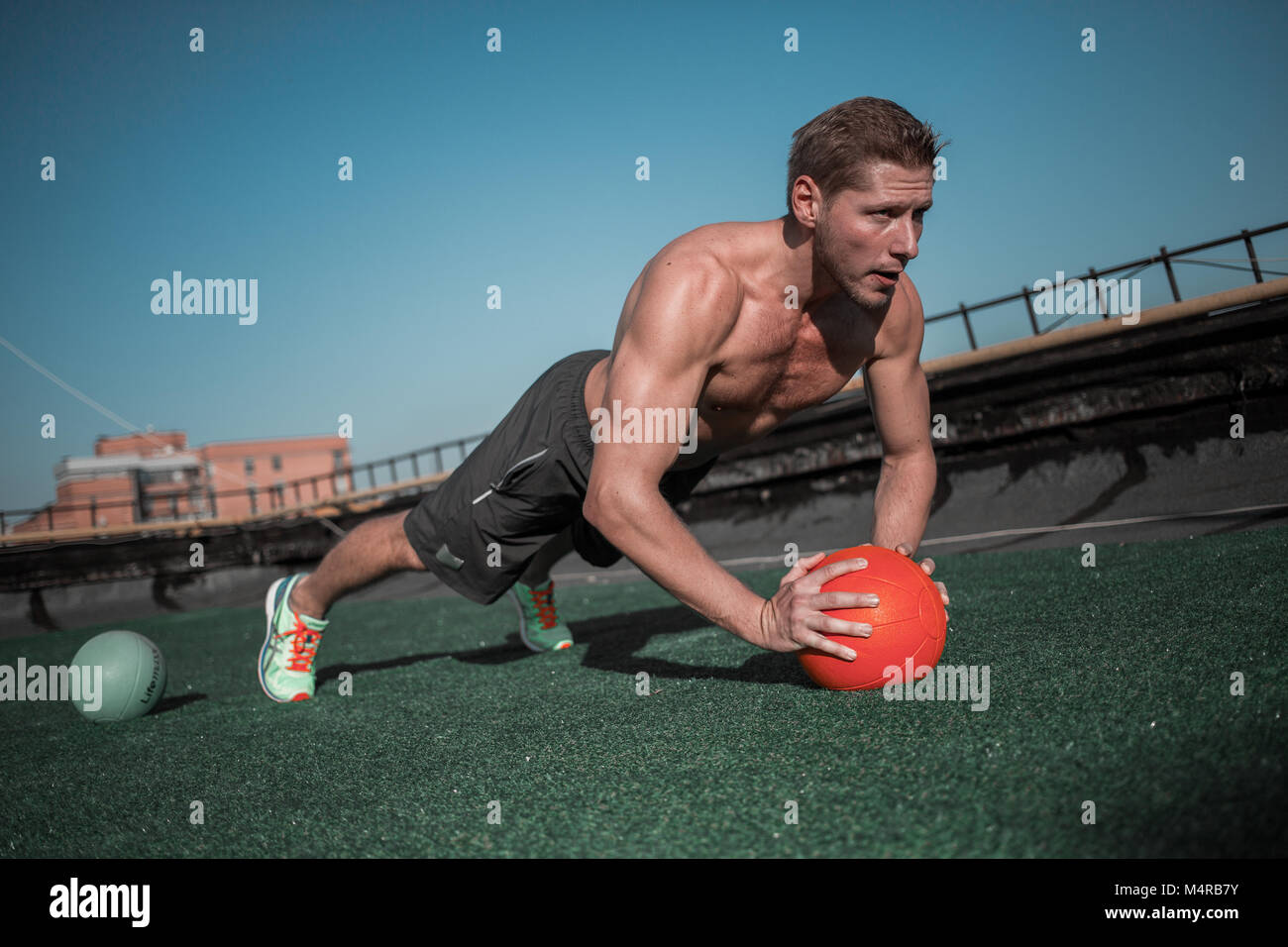 Sportivo da uomo con palla a lavorare su abs e i muscoli della spalla. Foto Stock Sportivo da uomo con palla a lavorare su abs e i muscoli della spalla. Foto Stock