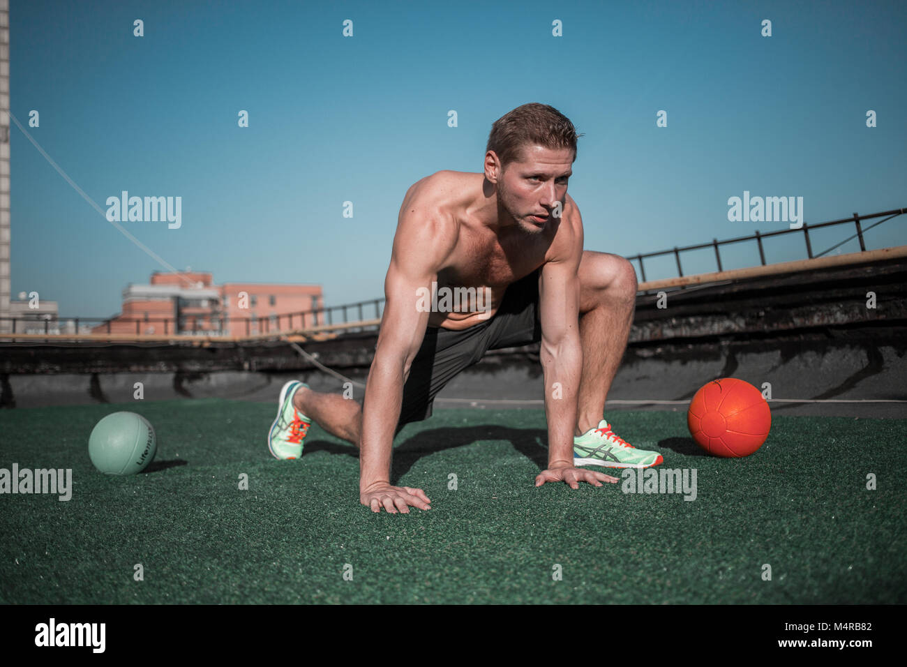 Sport sul concetto del tetto, atletico uomo che lavora fuori in una giornata di sole. Foto Stock