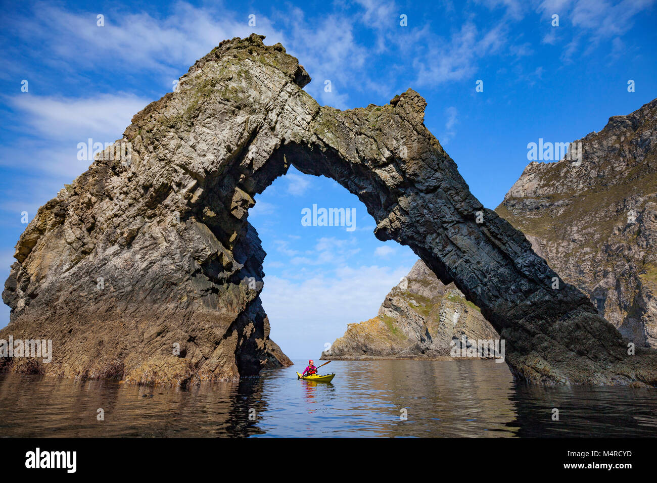 Kayak di mare sotto un arco naturale vicino Sturrall, Glencolmcille, County Donegal, Irlanda. Foto Stock