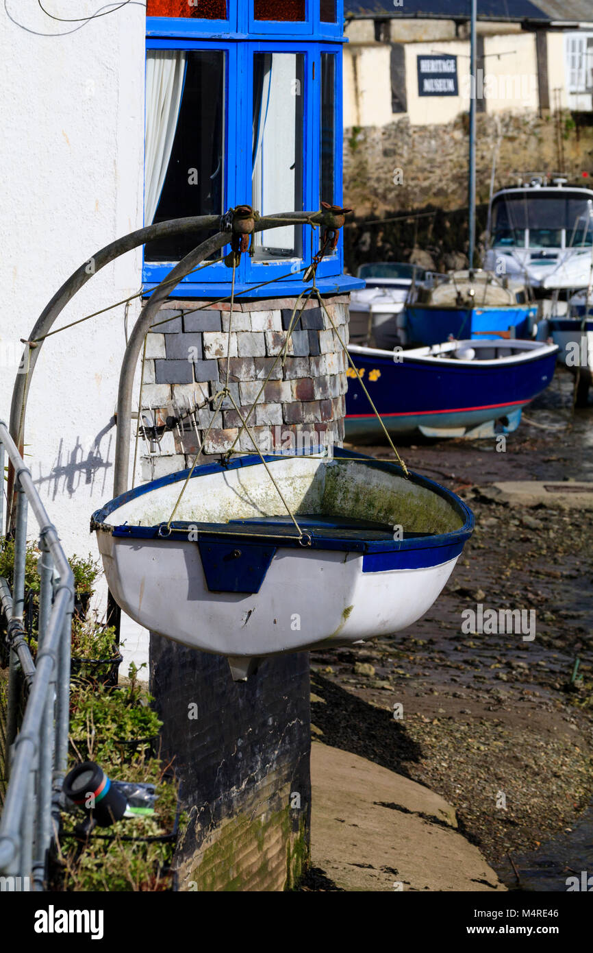 Blu e bianco su dinghy gruette contrasta con il dipinto di muri di casa all'Harbourside a Polperro, Cornwall, Regno Unito Foto Stock