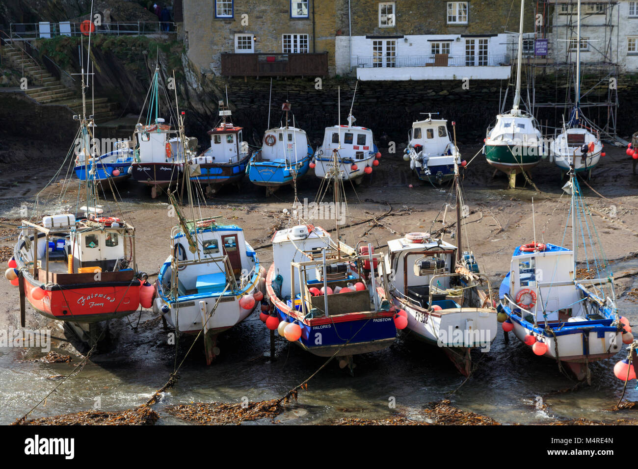 Costiera colorate barche da pesca spiaggiata a bassa marea a Polperro Harbour, Cornwall, Regno Unito Foto Stock