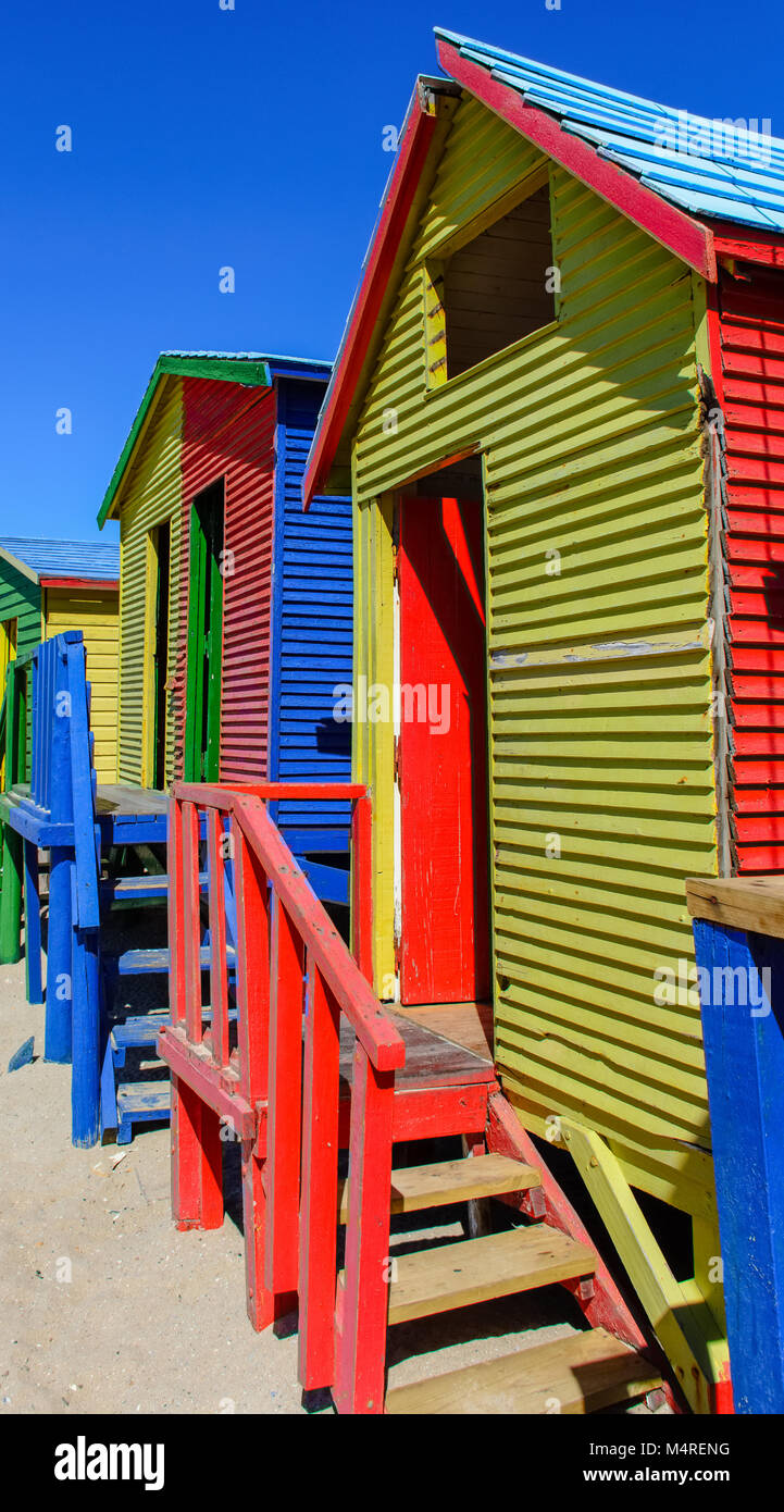 Famoso Vittoriano colorate scatole di balneazione presso San Giacomo Beach, Città del Capo, Sud Africa, presa su un soleggiato chiaro luminoso giorno sotto il cielo blu Foto Stock