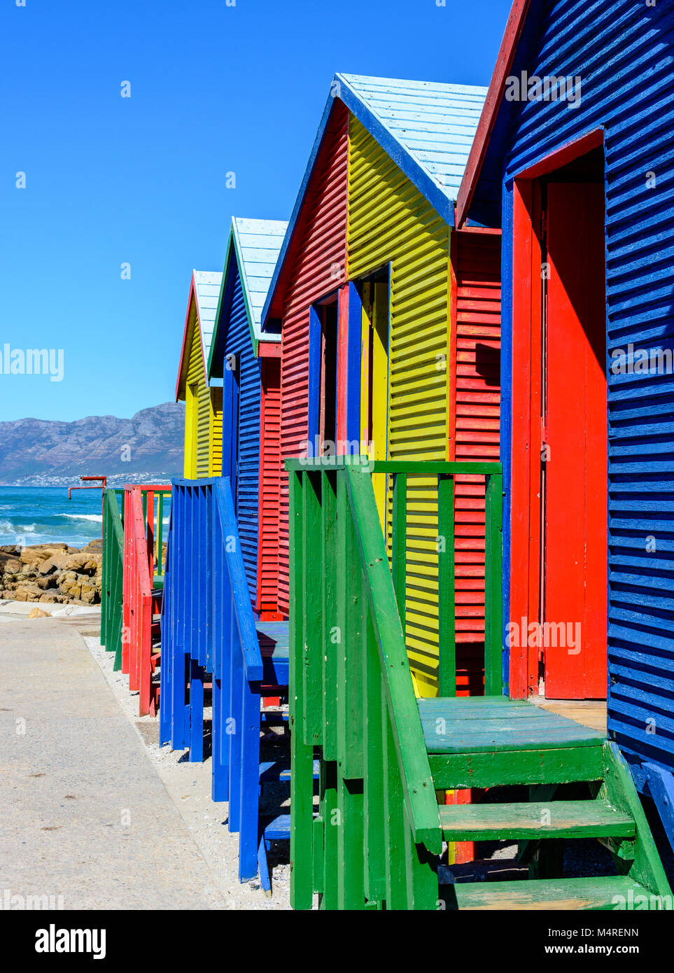 Famoso Vittoriano colorate scatole di balneazione presso San Giacomo Beach, Città del Capo, Sud Africa, presa su un soleggiato chiaro luminoso giorno sotto il cielo blu con il mare,ondata Foto Stock