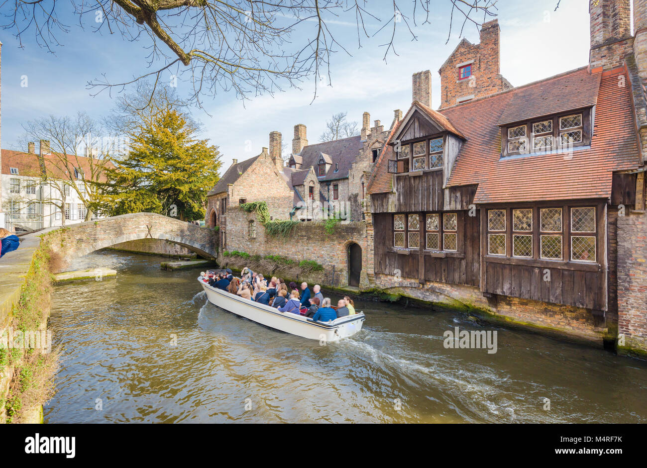 Centro storico di Brugge con turisti facendo un giro in barca lungo il case tradizionali in una bella giornata di sole con cielo blu, le Fiandre, in Belgio Foto Stock