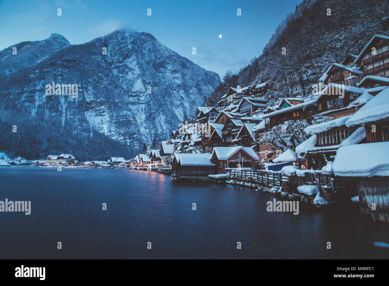 Classic vista da cartolina di tradizionali case di legno nella famosa Hallstatt Lakeside Town nelle Alpi nel crepuscolo mistico durante il blu ora di notte, Austria Foto Stock