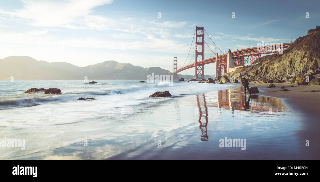 Classic vista panoramica del famoso Golden Gate Bridge visto da scenic Baker Beach in beautiful Golden luce della sera in una giornata di sole con cielo blu Foto Stock