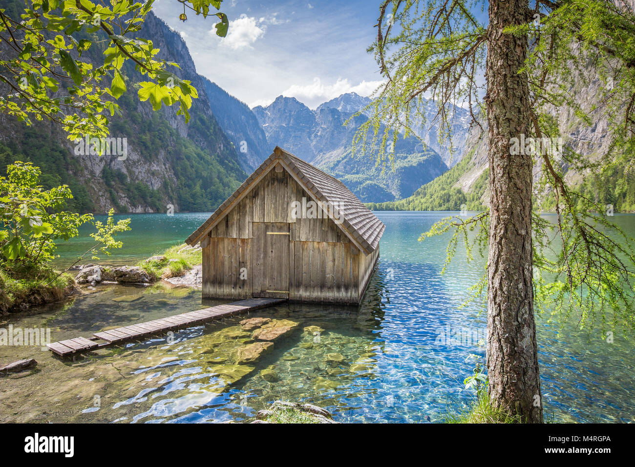 Barca di legno tradizionale casa sulle rive del famoso lago Obersee in Nationalpark Berchtesgadener Land in una giornata di sole in estate, Baviera, Germania Foto Stock