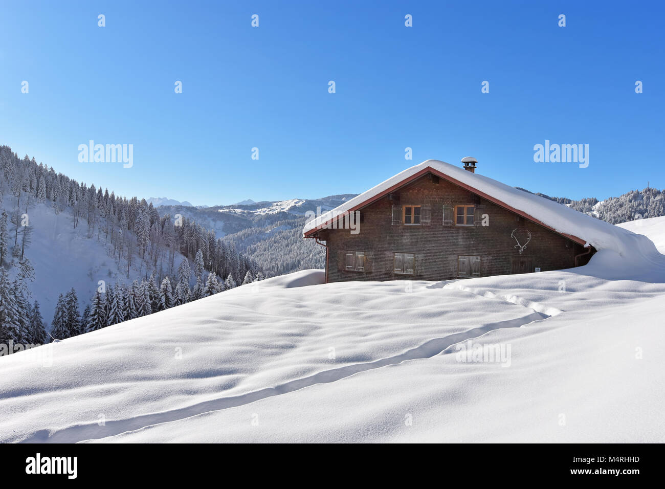 Profondamente paesaggio innevato in Algovia orientale delle Alpi con foreste e un rifugio alpino in una bella giornata d'inverno. La Baviera, Germania Foto Stock