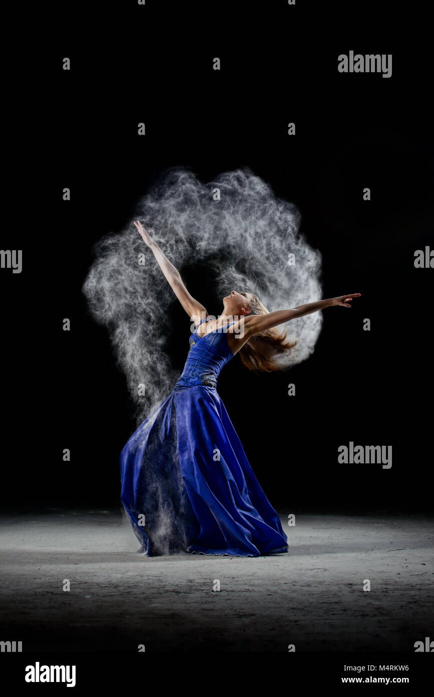 Il dancing girl nel buio, fare arte prestazioni con polvere bianca nuvola. Foto Stock